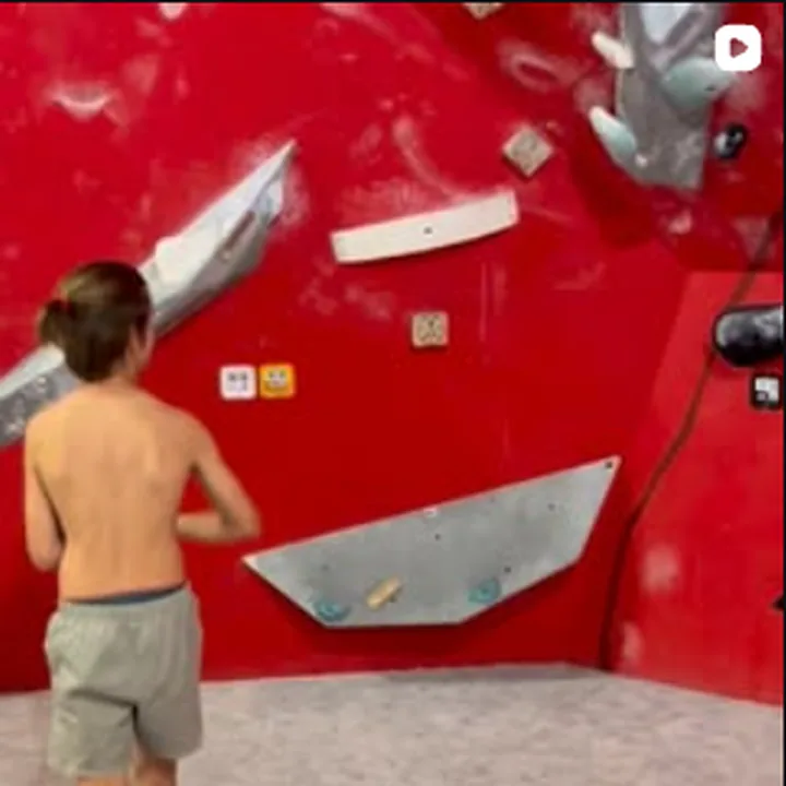 Mladý lezec pred boulderingovou stenou